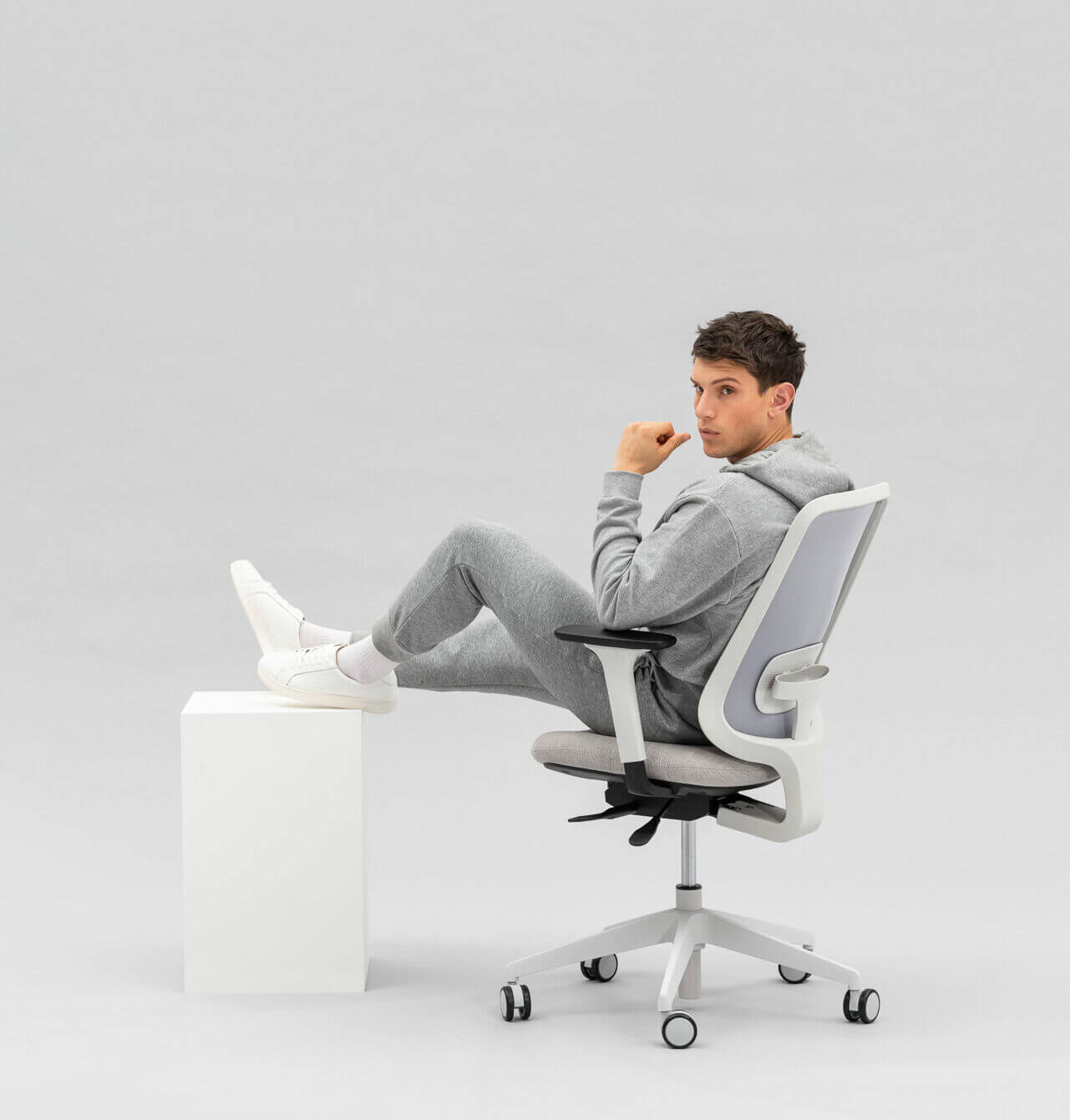 Person Sitting on Task One Grey Frame Office Chair With Their Feet on a Box