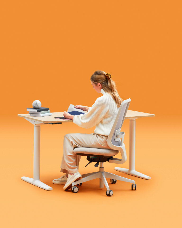 Person Reading at a Slouch Office Chair and Desk Setup in a Ginger Background