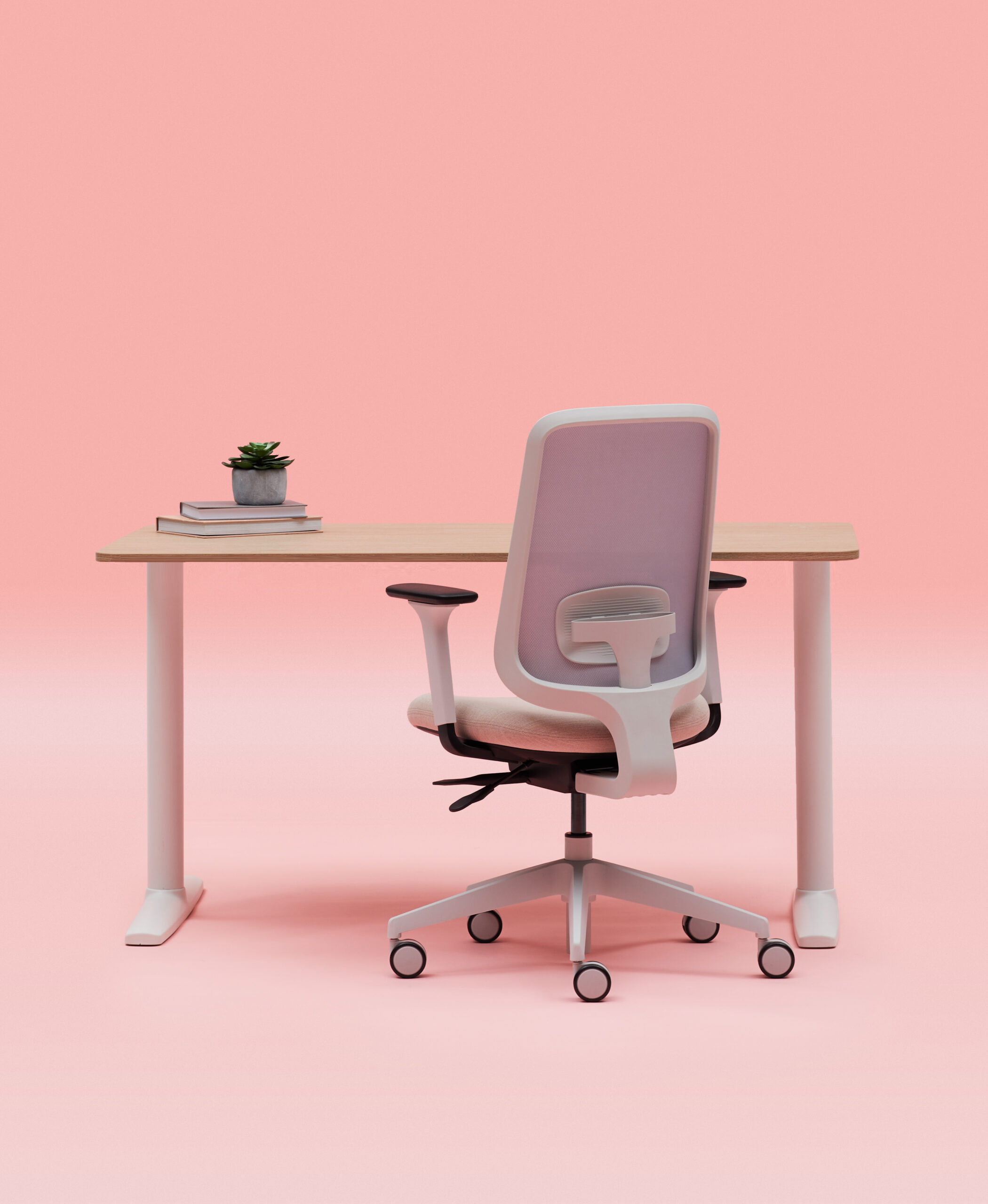 Grey Frame Office Chair With Arms Tucked Under a Fixed Height White Frame Desk