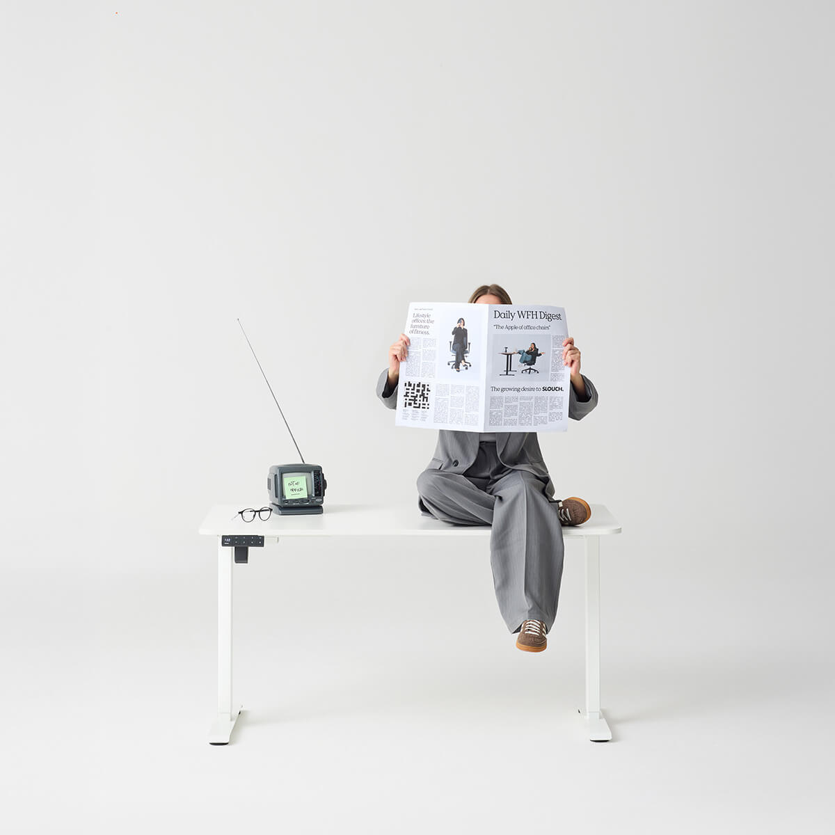 A model sat on a slouch desk with a white top and white frame