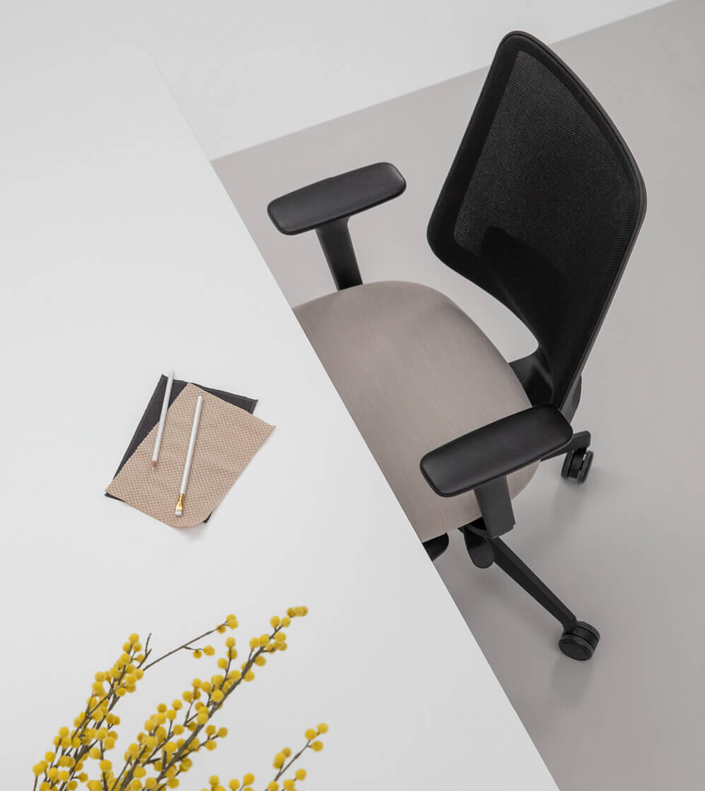 Birds Eye View of a Desk With a White Top and a Black Frame Office Chair With Arms